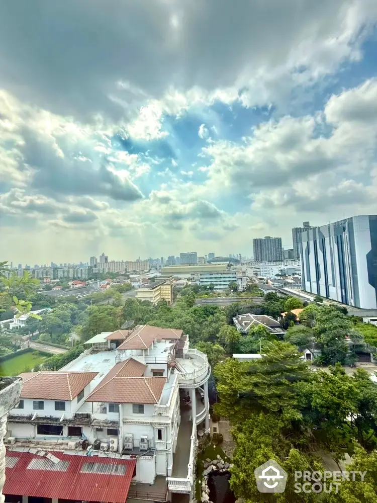 Stunning cityscape view from high-rise building with lush greenery and modern architecture.