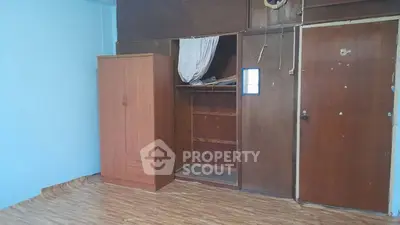 Spacious room with wooden wardrobe and unique flooring, ideal for creative renovation.
