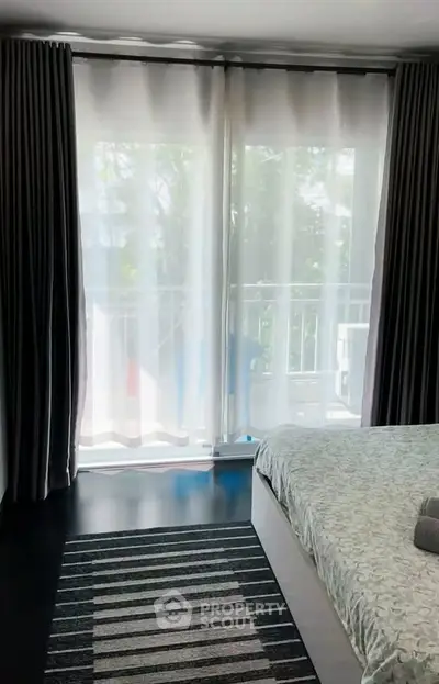 Cozy bedroom with balcony access and elegant curtains