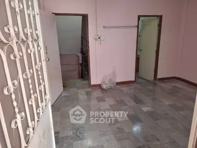 Spacious room with tiled floor and open doorways in a residential property