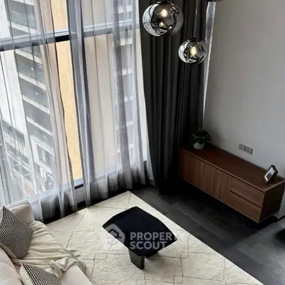 Modern living room with floor-to-ceiling windows and stylish decor in urban apartment.