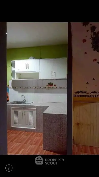 Charming kitchen with modern cabinetry and tiled countertops, perfect for culinary enthusiasts.