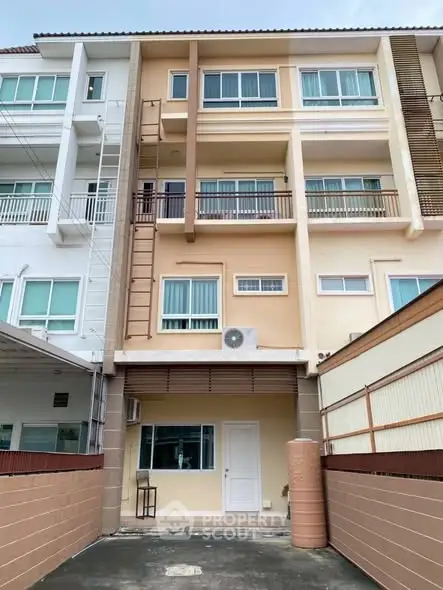Modern multi-story townhouse with beige facade and large windows