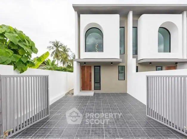 Modern duplex exterior with sleek design and gated entrance, perfect for contemporary living.