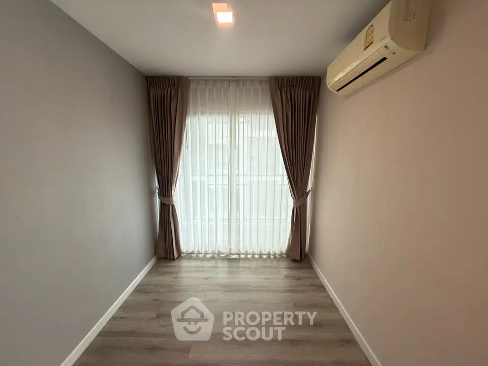 Spacious empty room with elegant curtains and air conditioning, perfect for customization.