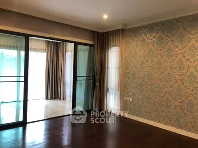 Spacious living room with elegant wallpaper and large sliding glass doors