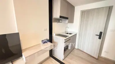 Modern compact kitchen with sleek cabinetry and integrated appliances in a stylish apartment.