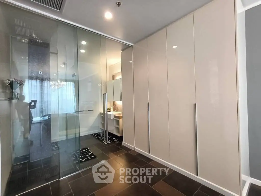 Modern bathroom with glass partition and sleek cabinetry