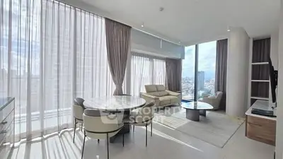 Spacious modern living room with panoramic city views and elegant furnishings.