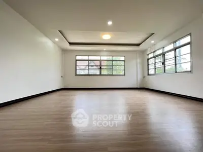 Spacious and bright living room with large windows and modern lighting.