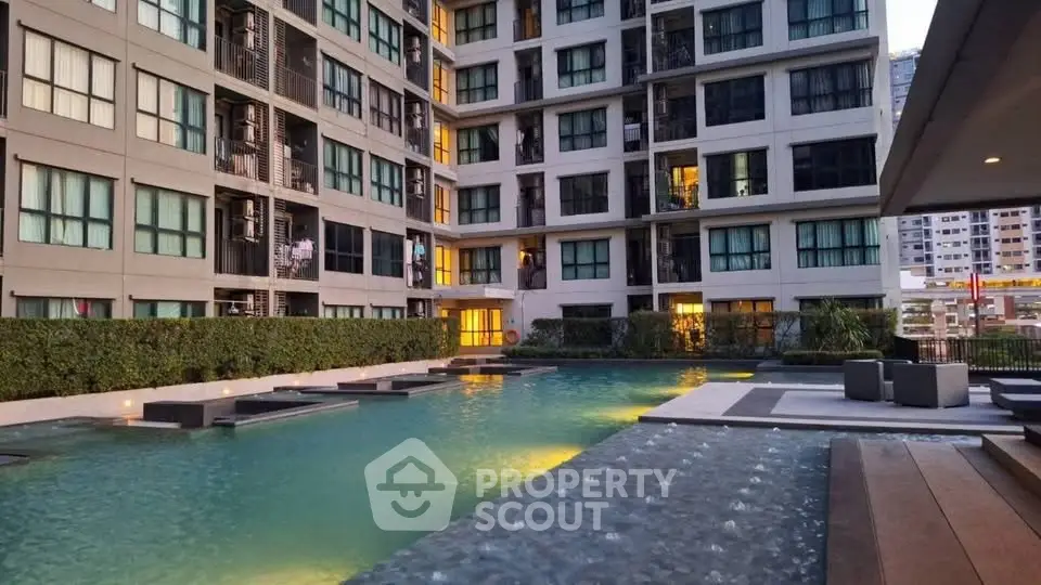Modern apartment complex with a luxurious outdoor pool and stylish seating area.