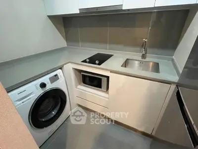 Modern compact kitchen with washing machine and sleek appliances