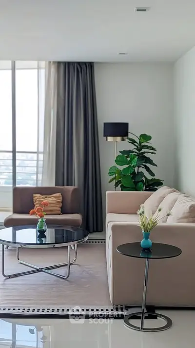 Modern living room with elegant furniture and large window offering natural light.