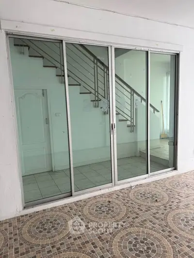 Spacious interior with sliding glass doors and tiled flooring, perfect for modern living.