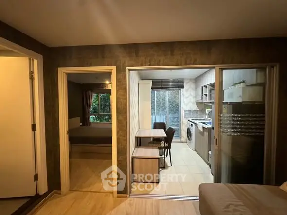 Modern apartment interior with open kitchen and dining area, featuring sleek appliances and cozy decor.