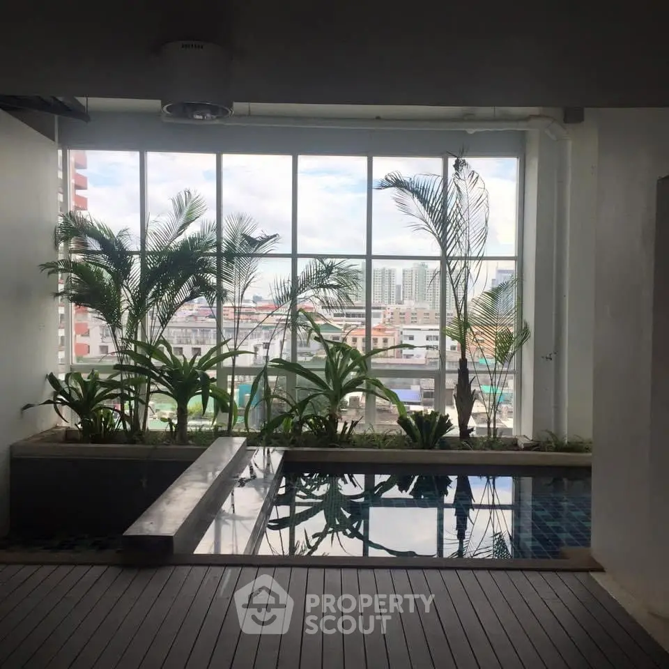 Stylish indoor pool with city view and lush greenery for a serene urban escape.