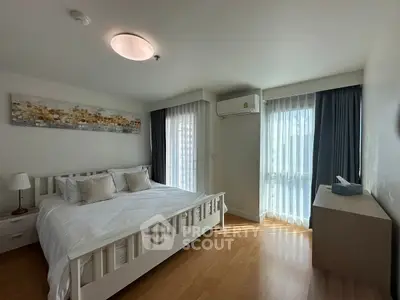 Spacious bedroom with natural light and modern decor in a stylish apartment.
