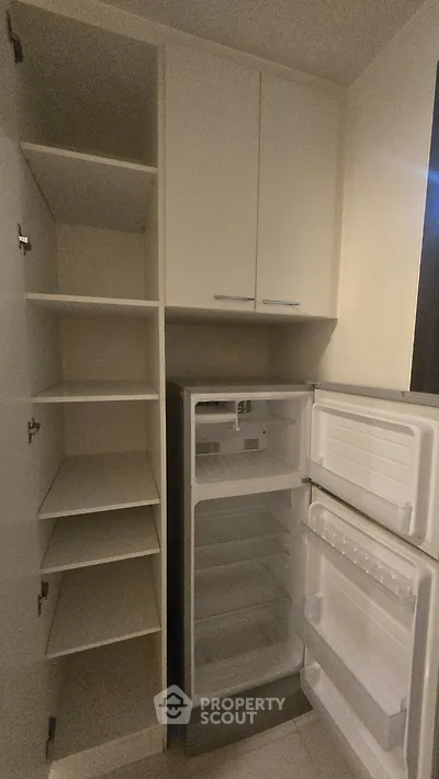 Spacious kitchen storage with built-in fridge and ample shelving for modern convenience.
