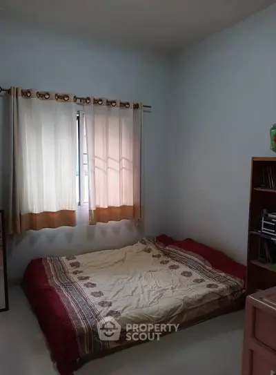 Cozy bedroom with natural light and simple decor, ideal for restful nights.