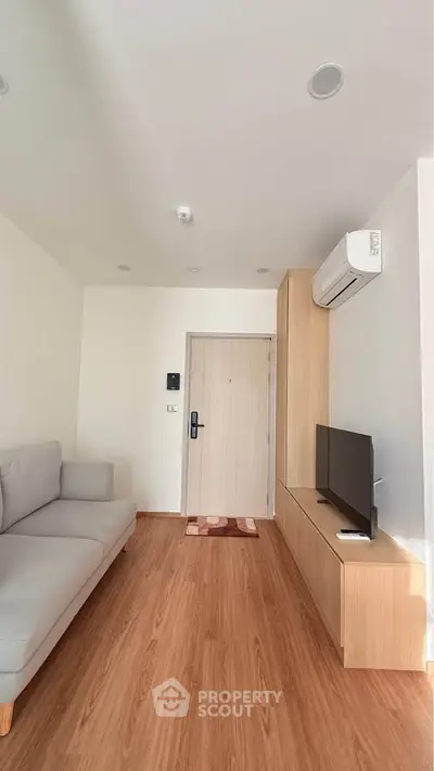 Modern living room with sleek wooden flooring and minimalist furniture design.