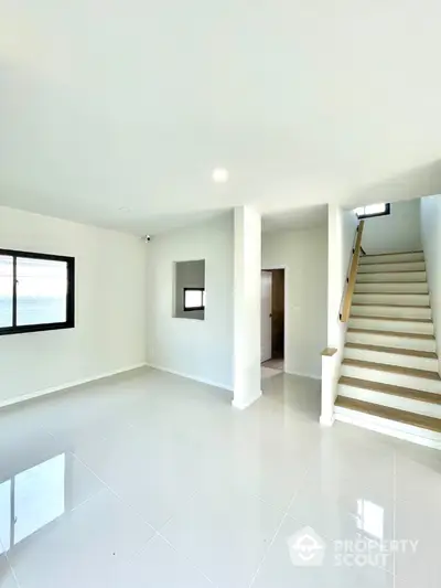 Spacious modern living room with staircase and large windows