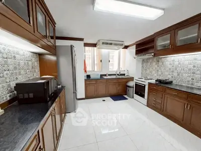 Spacious kitchen with modern appliances and elegant wooden cabinetry in a bright, airy setting.
