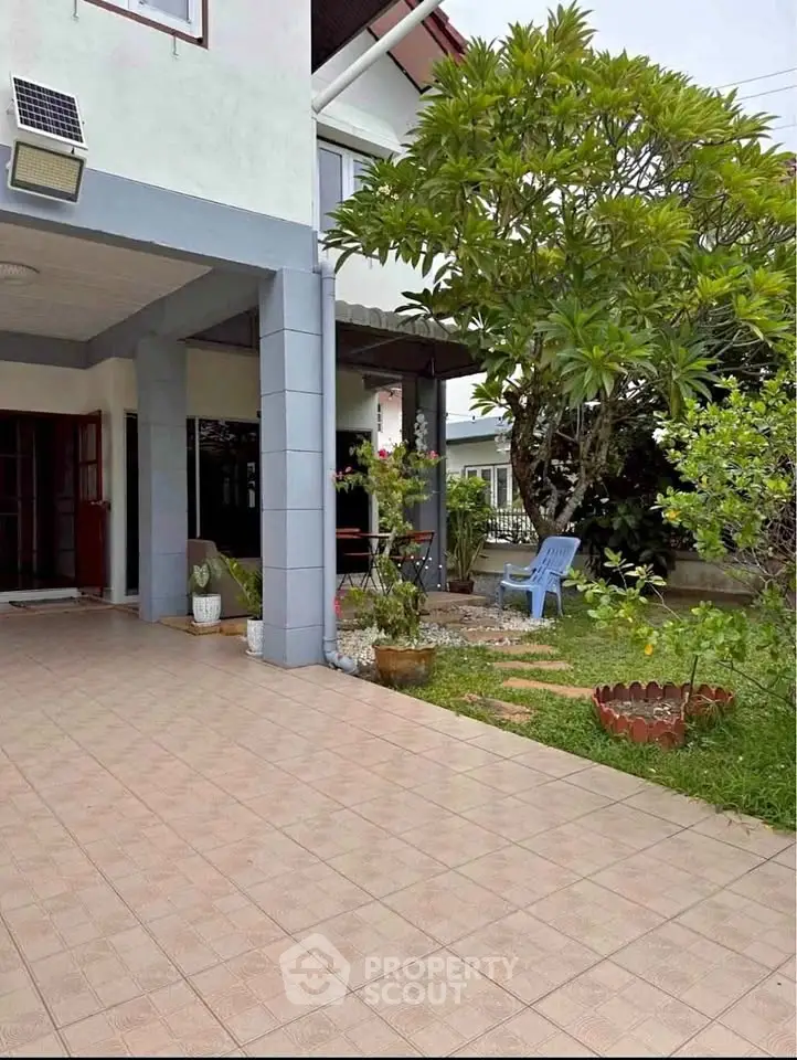 Charming suburban home with lush garden and spacious patio, perfect for outdoor relaxation.