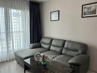 Modern living room with gray sofa and marble coffee table, featuring elegant decor and natural light.