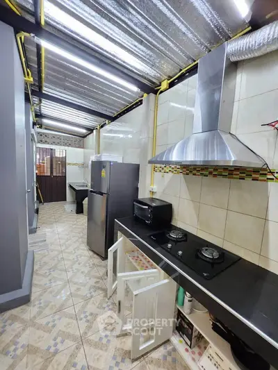 Modern kitchen with gas stove and stainless steel appliances in a sleek design.