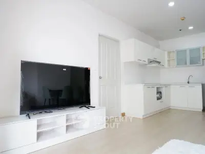 Modern open-plan living room with sleek kitchen and large TV unit, perfect for contemporary living.
