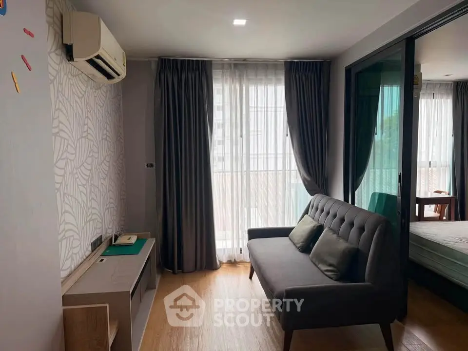 Modern living room with stylish sofa and large window, featuring elegant curtains and air conditioning.