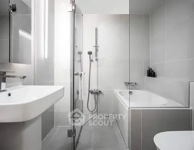 Modern bathroom with sleek design, featuring a bathtub and glass shower enclosure.
