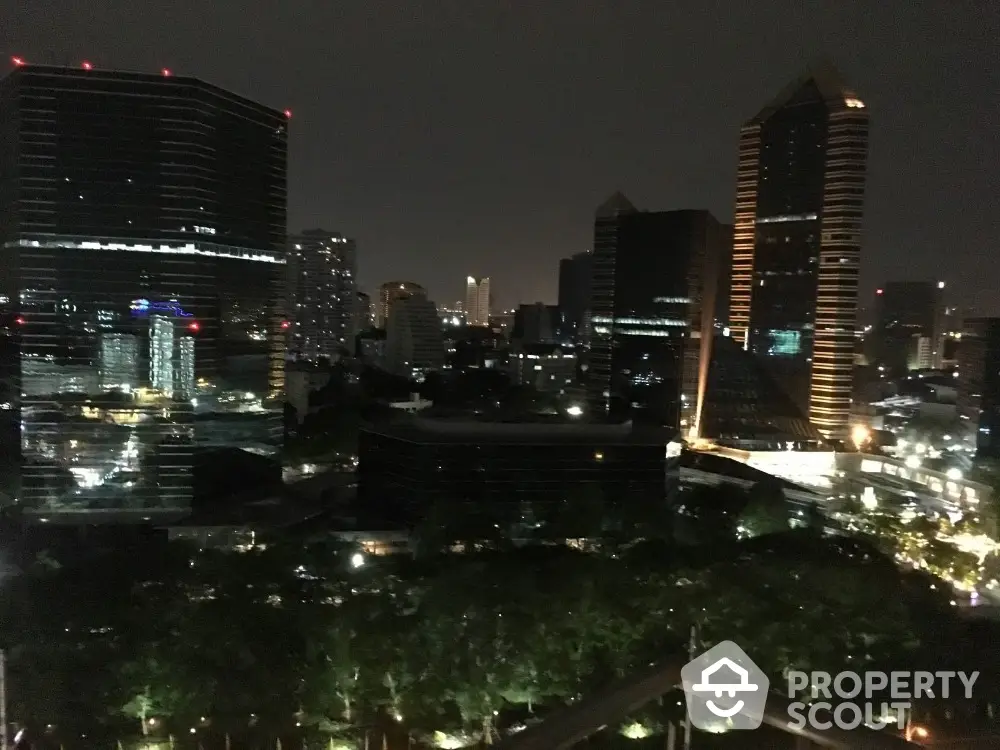 Stunning nighttime cityscape view from high-rise balcony overlooking urban skyline.