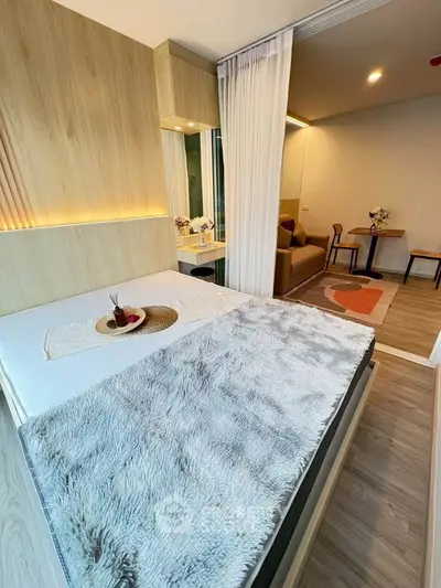 Modern studio apartment with cozy bedroom and stylish living area, featuring elegant decor and warm lighting.
