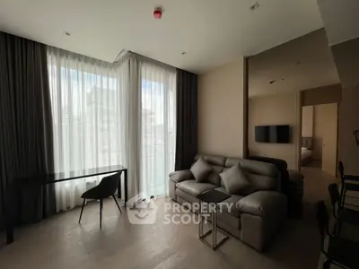 Modern living room with sleek furniture and large windows in a stylish apartment.
