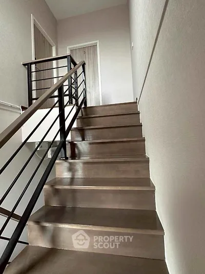 Modern staircase with sleek metal railing in contemporary home interior.