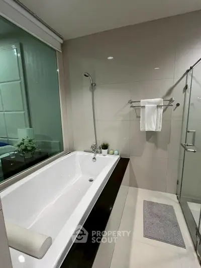 Modern bathroom with sleek bathtub and glass shower enclosure