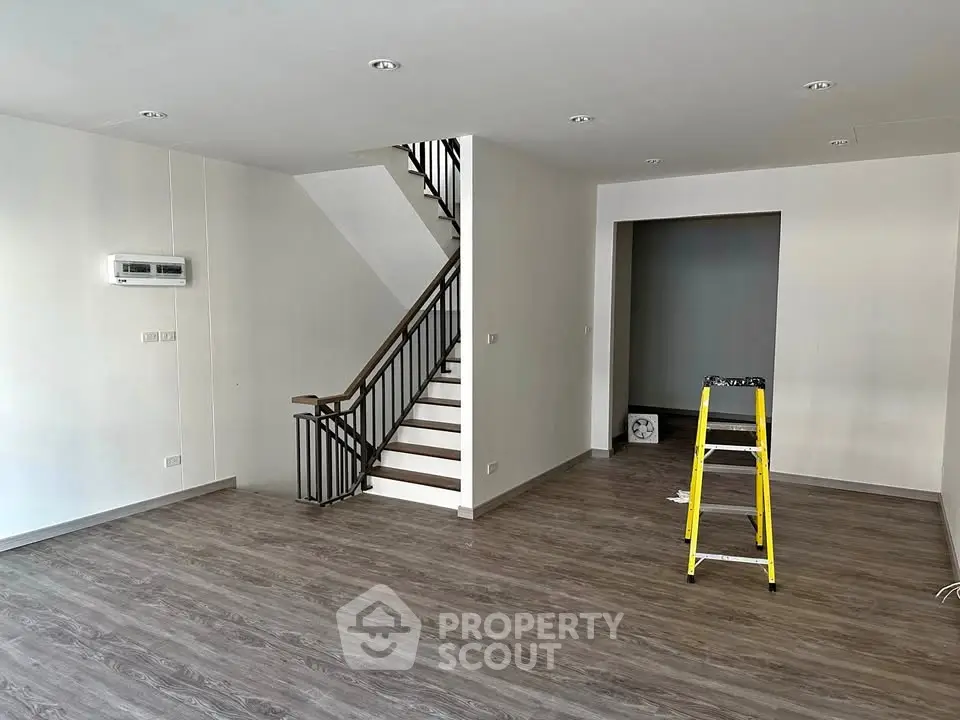 Spacious modern living room with elegant staircase and sleek flooring