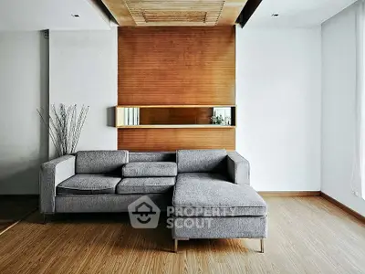 Modern living room with stylish gray sectional sofa and wooden accent wall