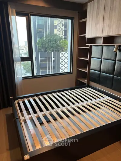 Modern bedroom with large window and built-in storage in urban apartment
