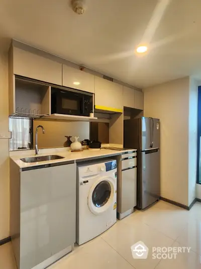 Modern kitchen with sleek appliances and washing machine in stylish apartment