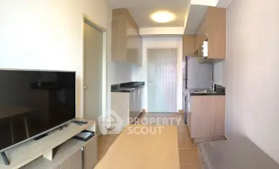 Modern compact living room with open kitchen layout and sleek wooden cabinetry.