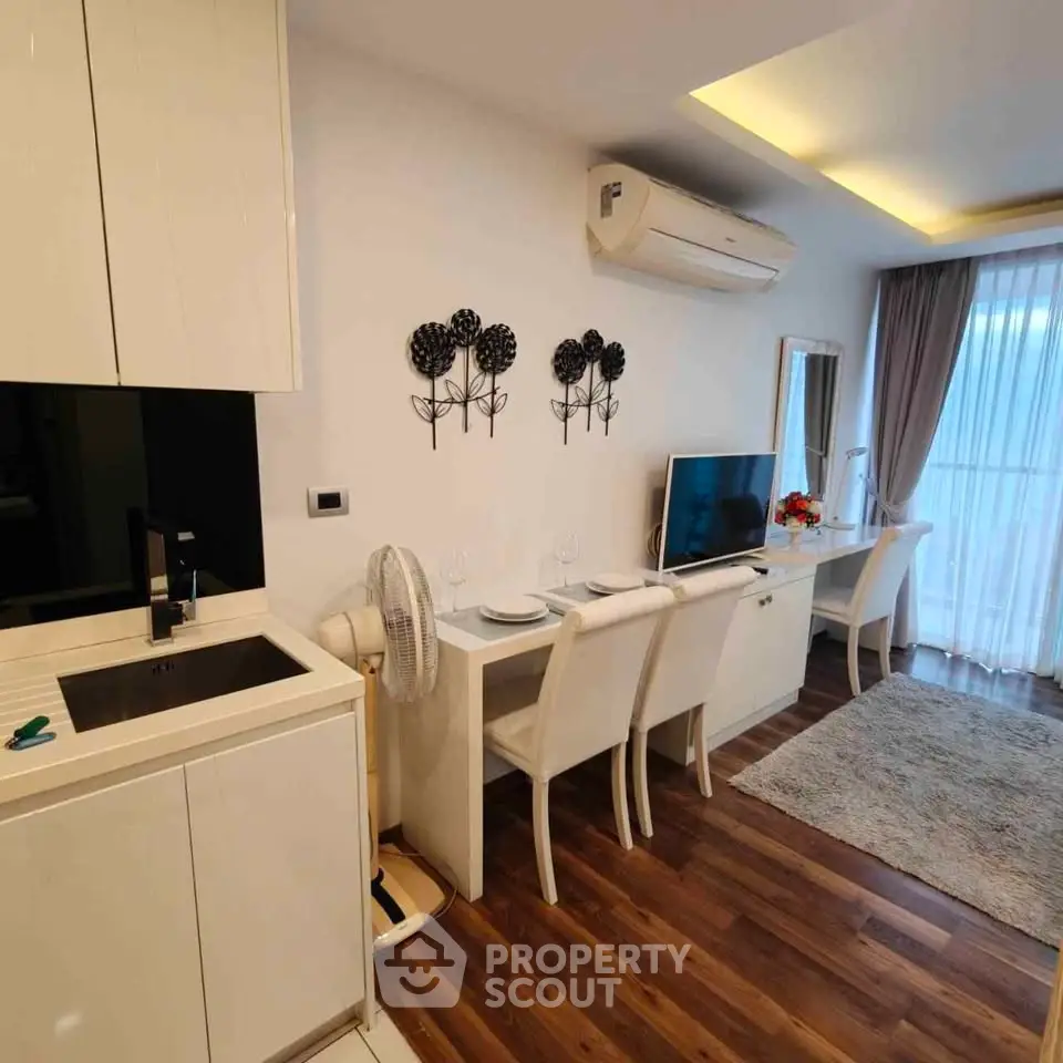 Modern living room with sleek kitchen, dining area, and stylish decor in a cozy apartment.