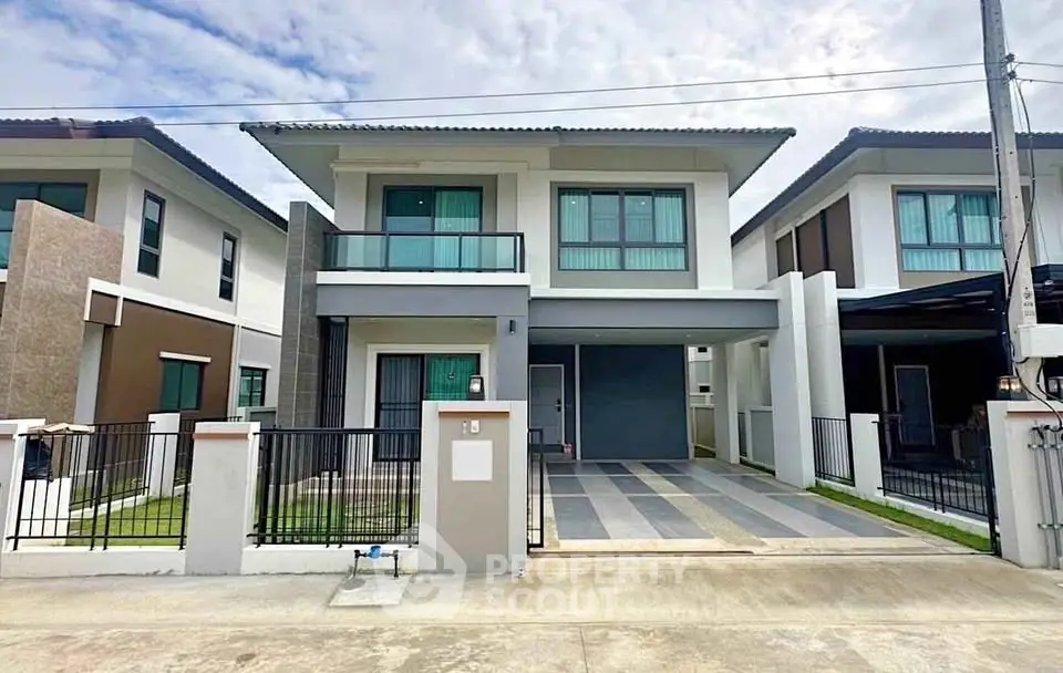 Modern two-story house with sleek design and spacious driveway in a suburban neighborhood.