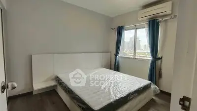 Modern bedroom with city view, featuring a large window and air conditioning.