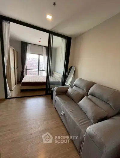 Modern apartment interior with cozy living room and bedroom, featuring stylish furniture and large windows.