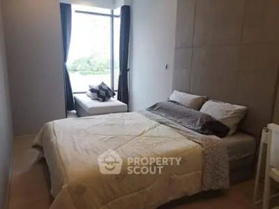 Cozy bedroom with large window and modern decor in urban apartment