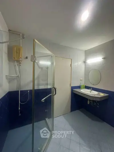 Modern bathroom with glass shower and sleek vanity in a stylish home.