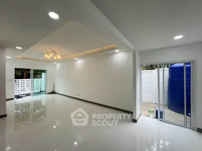 Spacious modern living room with elegant lighting and sliding glass doors to outdoor area.