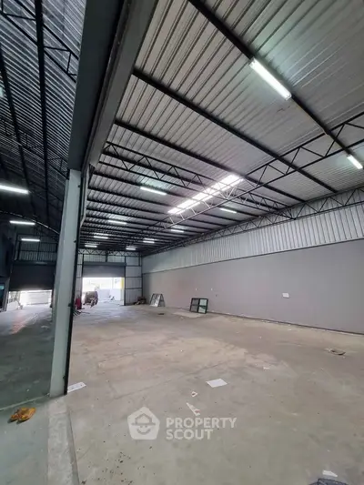 Spacious industrial warehouse with high ceilings and ample natural light.